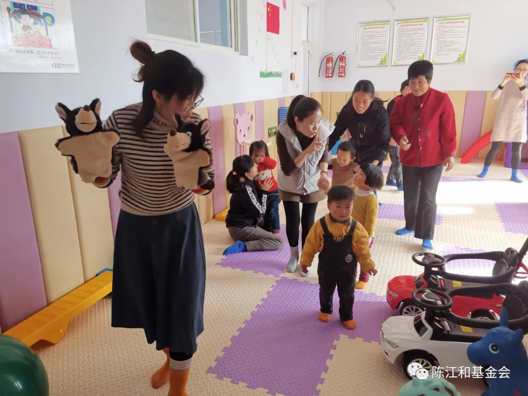 养育师带领婴幼儿及家长进行集体游戏